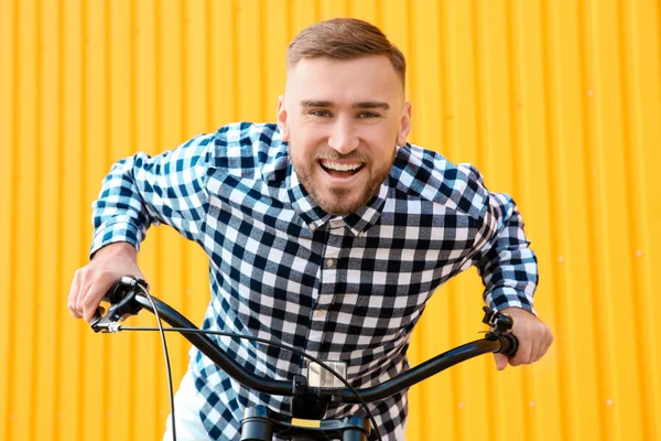 Guapo joven hipster hombre con bicicleta cerca de la pared al aire libre — Foto de Stock