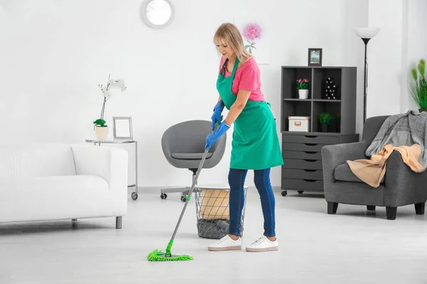 Zralá žena vytírání podlahy doma — Stock fotografie