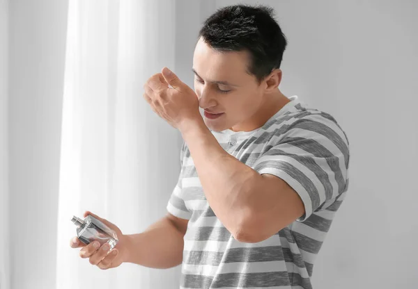Pohledný mladý muž doma pomocí parfém — Stock fotografie