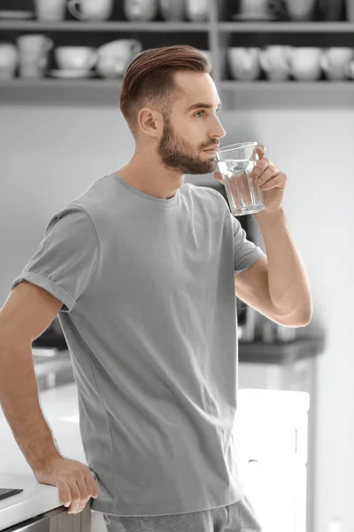早晨英俊的年轻人在厨房里喝水 — 图库照片