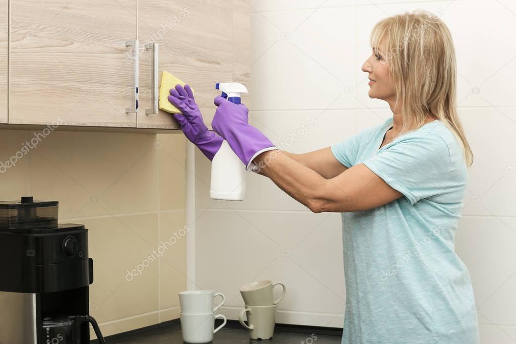 Mature woman cleaning kitchen