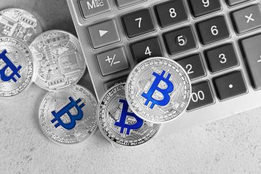 Grunge arka plan üzerinde hesap makinesiyle gümüş bitcoins