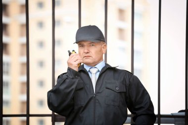 Erkek güvenlik görevlisi taşınabilir radyo açık havada kullanma