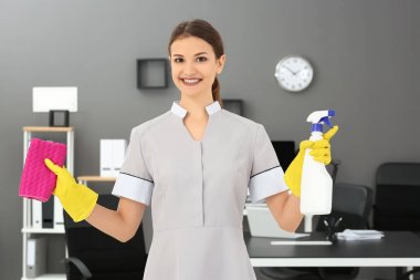 Şişe deterjan ve bez ofiste olan kadın