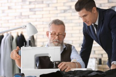 Atelier dikiş makinesi üzerinde çalışan üst düzey terzi