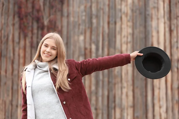 Hipster atrakcyjny dziewczynka kapelusz w pobliżu drewniany płot na zewnątrz — Zdjęcie stockowe