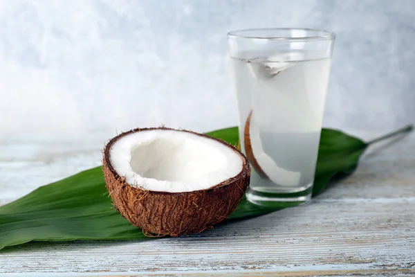 Copo de água de coco com porca no fundo de madeira — Fotografia de Stock