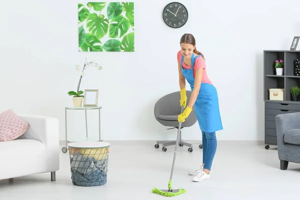 Giovane donna che pulisce pavimento a casa — Foto Stock