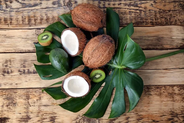 Komposition med färska kokosnötter och tropiska frukter på gröna blad — Stockfoto