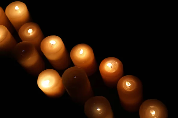 Viele brennende Kerzen auf dunklem Hintergrund — Stockfoto
