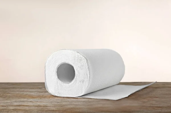 Rollo de toallas de papel sobre la mesa contra fondo claro — Foto de Stock