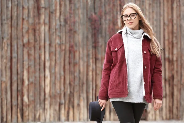 Aantrekkelijke hipster meisje met hoed in de buurt van houten hek buitenshuis — Stockfoto