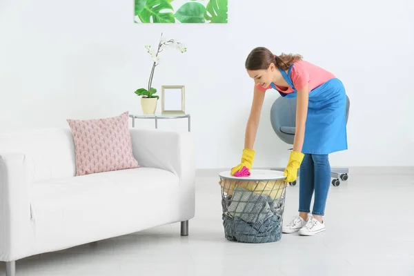 Mujer joven limpiando polvo mientras limpia plana — Foto de Stock