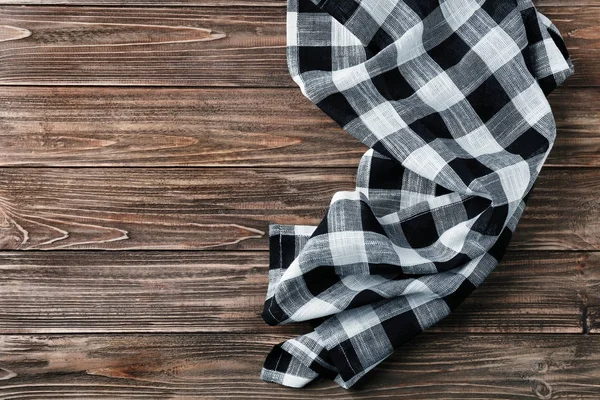 Checkered kitchen towel on wooden table — Stock Photo, Image