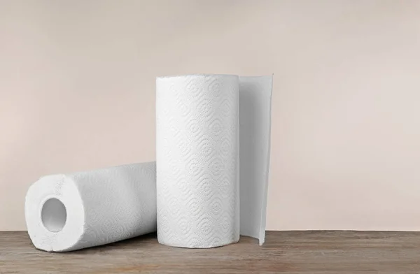 Rolls of paper towels on table against light background — Stock Photo, Image