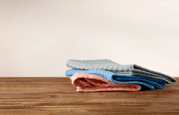 Asciugamani da cucina puliti sul tavolo contro lo sfondo chiaro — Foto Stock