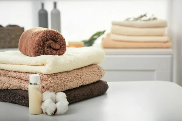 Conjunto de toalhas macias na mesa dentro de casa — Fotografia de Stock