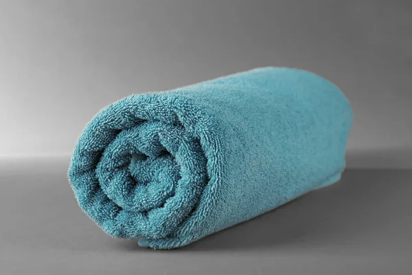 Rolou toalha terry no fundo cinza — Fotografia de Stock