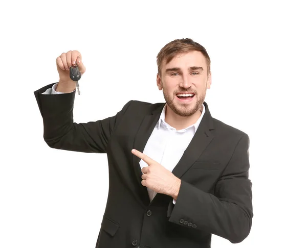 Man in formal suit holding car key on white background — Stock Photo, Image