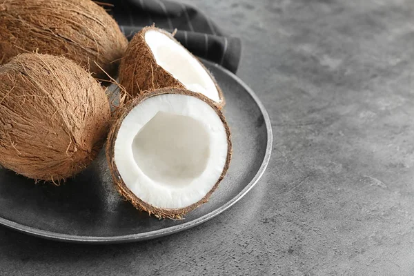회색 배경에 익은 코코넛와 트레이 — 스톡 사진