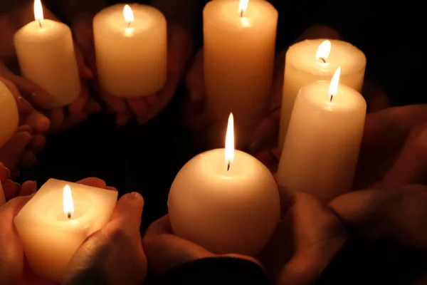 Manos con velas encendidas, primer plano — Foto de Stock