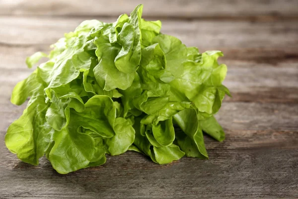 Stelletje frisse groene salade op houten tafel — Stockfoto