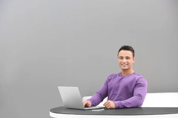 Młody człowiek za pomocą laptopa w biurze — Zdjęcie stockowe