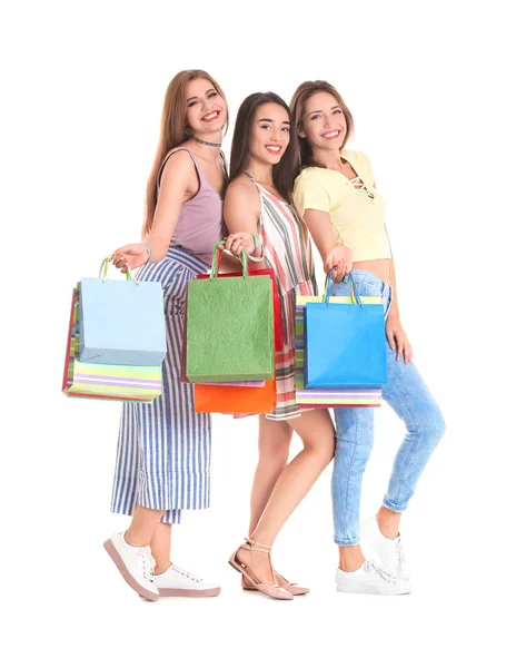 Heureuses jeunes femmes avec des sacs à provisions sur fond blanc — Photo