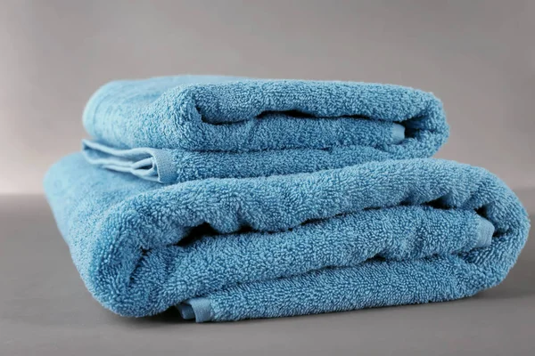 Weiche Frottee-Handtücher auf grauem Hintergrund — Stockfoto