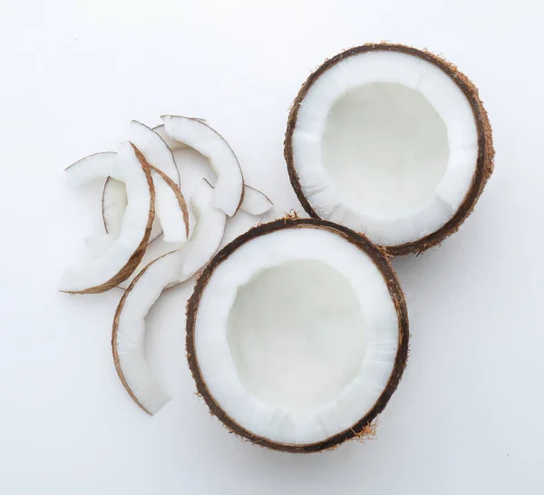 Половинки и куски кокоса на белом фоне — стоковое фото