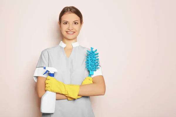 Donna con bottiglia di detergente e pennello su sfondo colore — Foto Stock