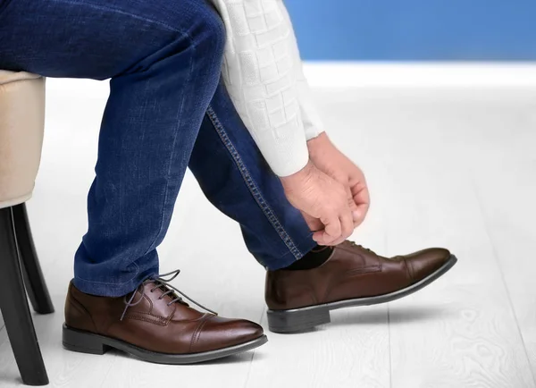 Homem colocando sapatos de couro elegantes dentro de casa, close-up — Fotografia de Stock