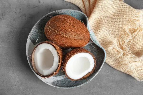 Тарелка со свежими кокосами на сером фоне — стоковое фото