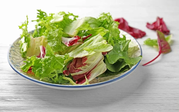 Beyaz ahşap masa üzerinde taze salata ile plaka — Stok fotoğraf