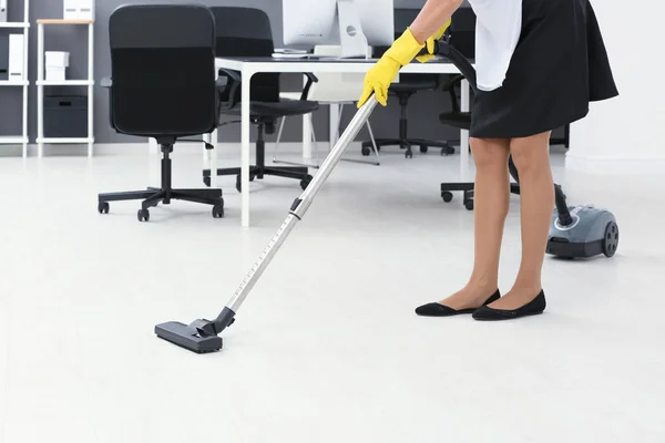 Charwoman hoovering chão no escritório com aspirador de pó — Fotografia de Stock