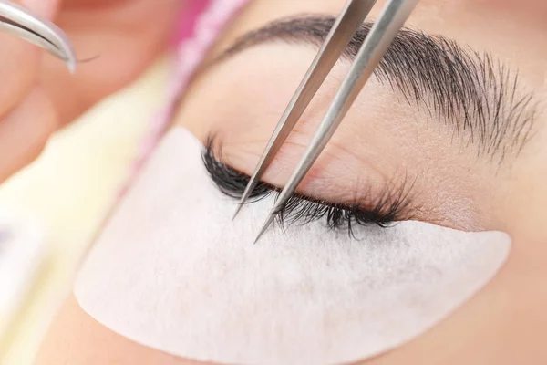 Junge Frau unterzieht sich einer Wimpernverlängerung, Nahaufnahme — Stockfoto