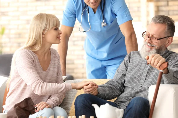 Caregiver with senior man and his daughter at home — Stock Photo, Image
