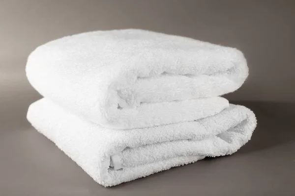Мягкие махровые полотенца на сером фоне — стоковое фото