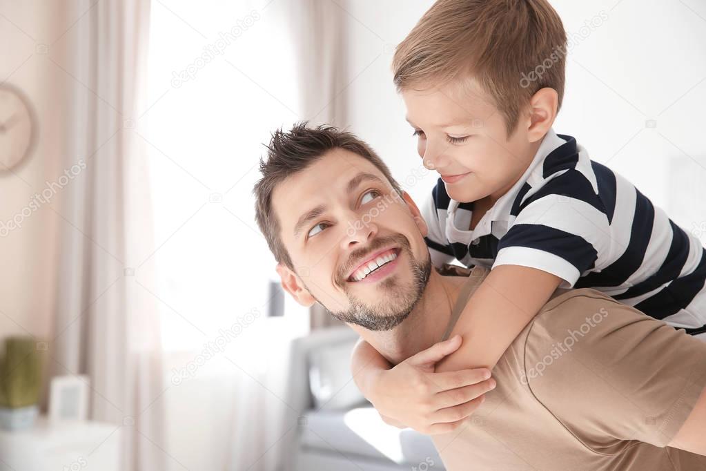 Cute little boy and father playing together at home