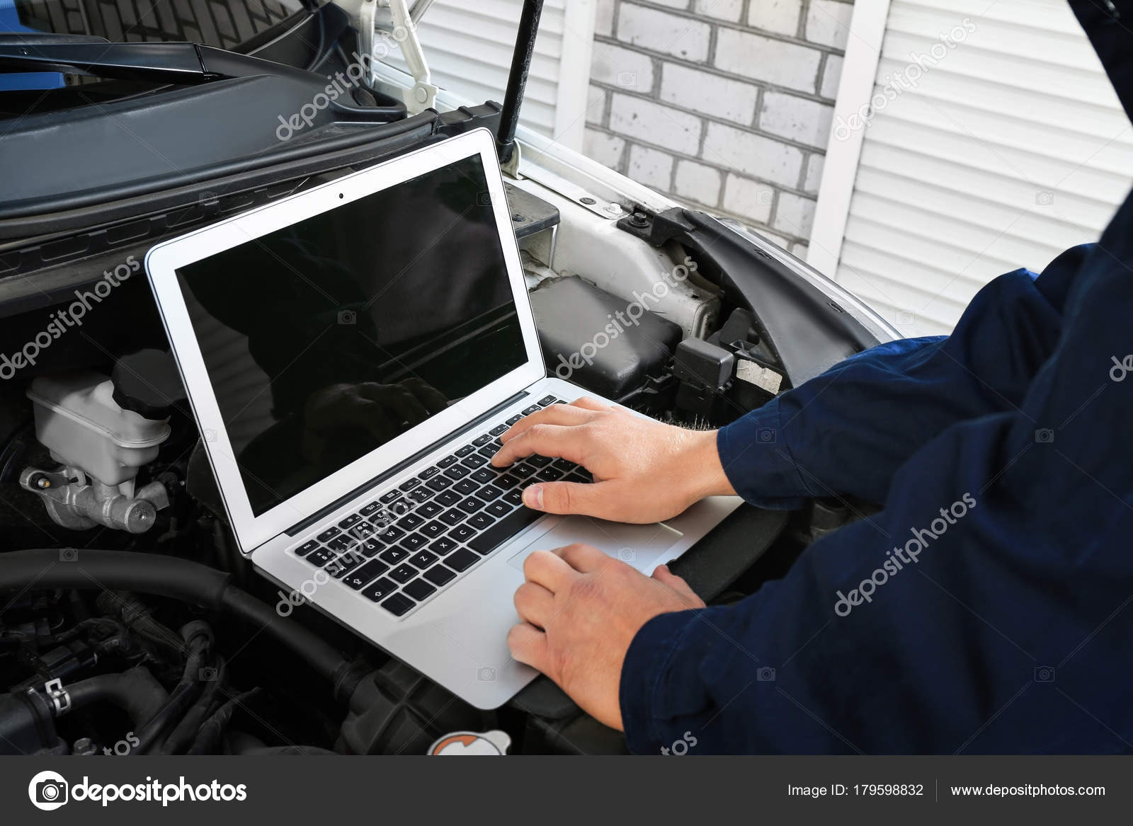 doorgaan krom Centraliseren Auto mechanic using computer diagnostic program while repairing car  outdoors Stock Photo by ©belchonock 179598832