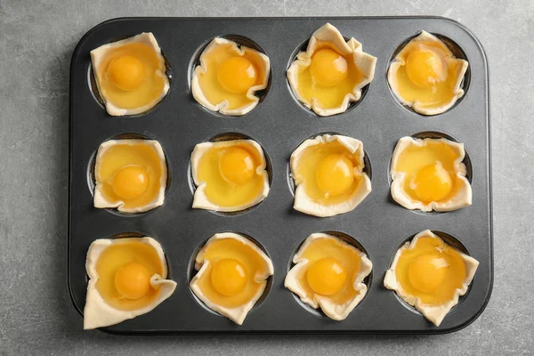 Baking mold with raw eggs in dough on table — Stock Photo, Image