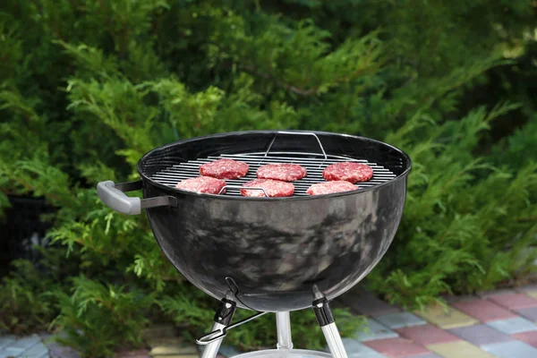 Barbecue grill met smakelijke pasteitjes op achtertuin — Stockfoto