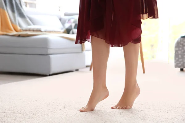 Femme debout sur un tapis blanc doux à la maison — Photo