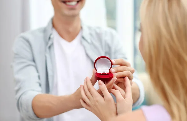 自宅の女性に結婚の提案を作る婚約指輪を持つ男 — ストック写真