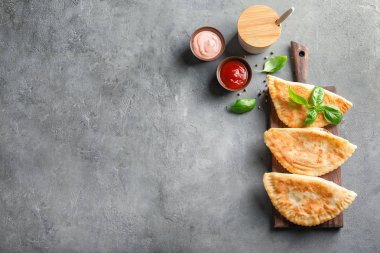 Gri arka plan üzerinde derin kızarmış samosas ile ahşap tahta