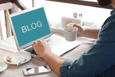 Kahve içme ve kafede dizüstü kullanarak genç blogger