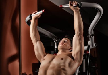 Spor salonunda egzersiz makinesi eğitim genç adam