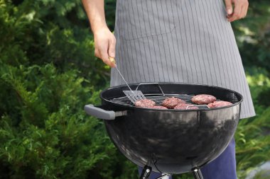 Adam açık havada mangal üzerinde leziz köftesi hazırlanıyor