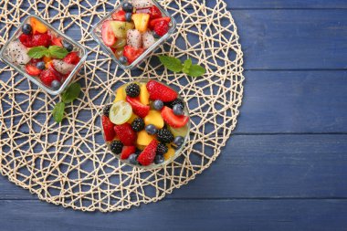 Tatlı ile ahşap masa üzerinde lezzetli meyve salatası kaseler