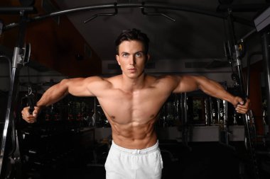 Spor salonunda egzersiz makinesi eğitim genç adam